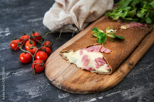 Foto Black wheat and wheat galette topped with cooked ham and emmental cheese