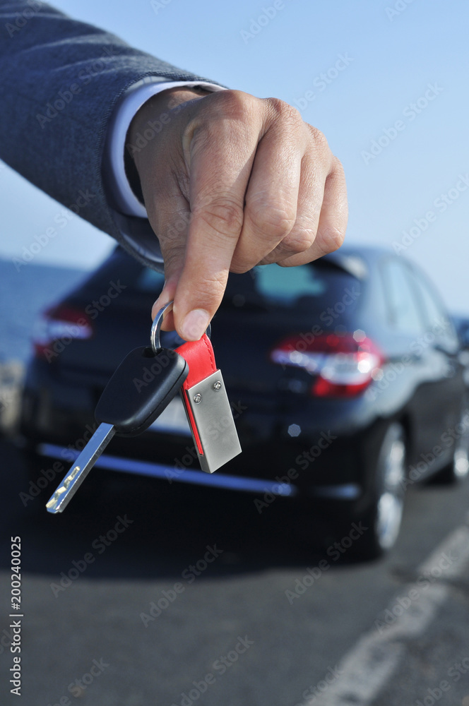 man offering a car key to the observer.