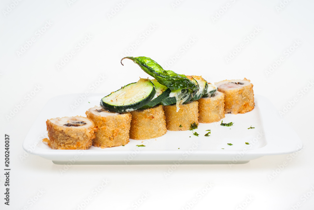 Chicken roll and vegetables on white plate