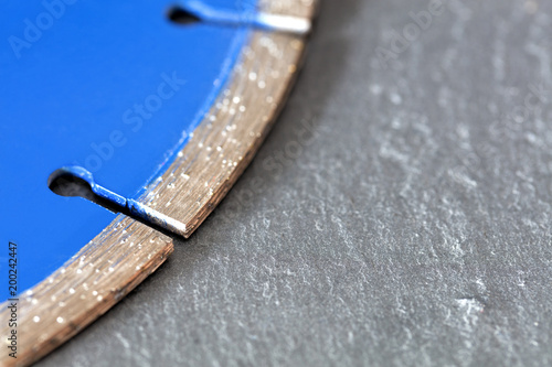 Segment of a diamond cutting disc on a background of gray concrete. photo