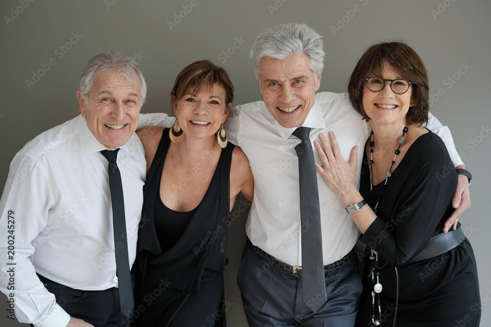 Cheerful fancy senior couples dressed up for party