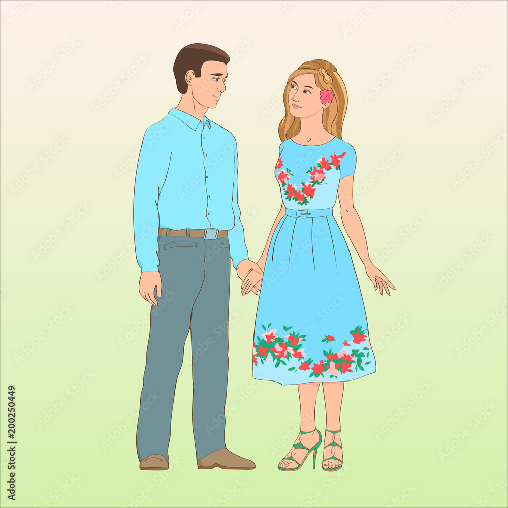 A young guy in trousers and a shirt stands with a girl in a blue dress. He holds her hand and lovingly looking at her. A young guy in trousers and a shirt stands with a girl in a blue dress. He holds her hand and lovingly looking at her.