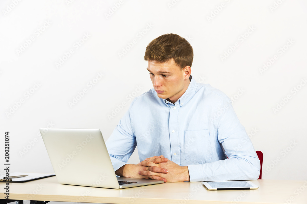 Happy young businessman using laptop at his office desk and thinking, look straight ahead. Happy young businessman using laptop at his office desk and thinking, look straight ahead.