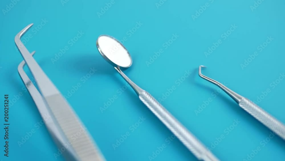 Set of dentist tools on green background: dentist mirror, forceps curved, explorer curved, dental explorer angular and explorer curved with chip, right. Dental Hygiene and Health conceptual image Set of dentist tools on green background: dentist mirror, forceps curved, explorer curved, dental explorer angular and explorer curved with chip, right. Dental Hygiene and Health conceptual image