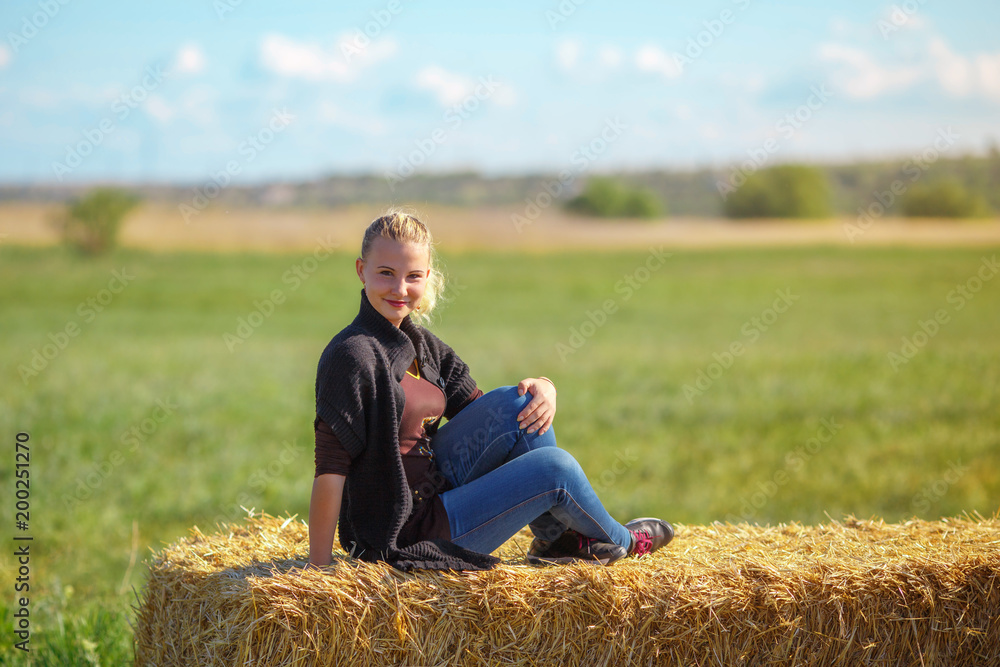 beautiful girl sits on a haystack beautiful girl sits on a haystack