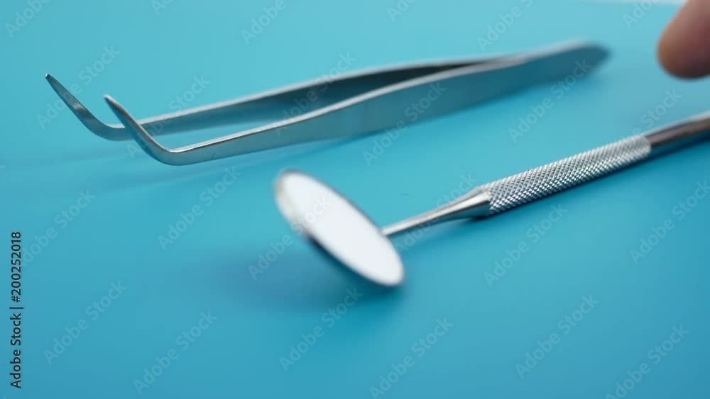 Professional Dentist tools in dental office: dentist mirror, forceps curved, explorer curved, dental explorer angular and explorer curved with chip, right. Dental Hygiene and Health conceptual image