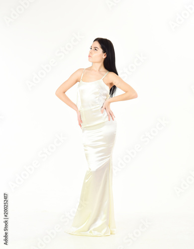 Health and body care concept. Woman in elegant white dress, white background. Fashion model with slim figure as result of dieting and fitness. Lady on dreamy face enjoy her sporty figure, shapes. © be free