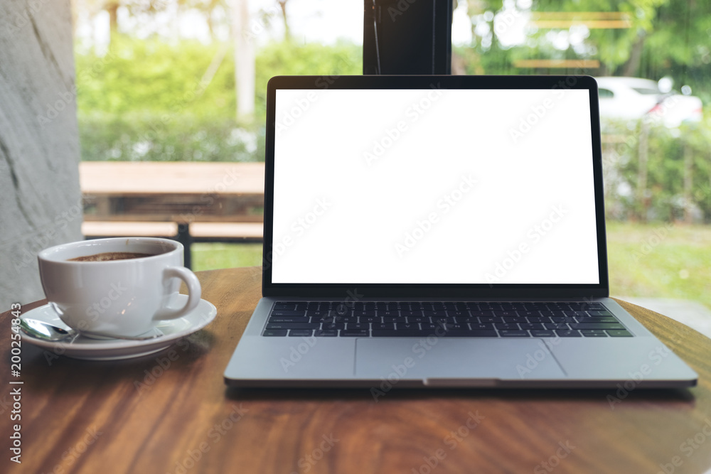 Mockup image of laptop with blank white desktop screen on wooden table in cafe Mockup image of laptop with blank white desktop screen on wooden table in cafe