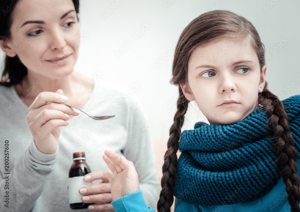 Leave me. Unhappy sick little girl sitting in the bright room turning from her mother and looking aside. Leave me. Unhappy sick little girl sitting in the bright room turning from her mother and looking aside.