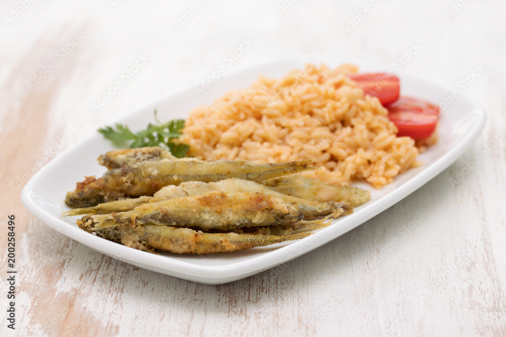 fried smelts with tomato rice on white dish fried smelts with tomato rice on white dish