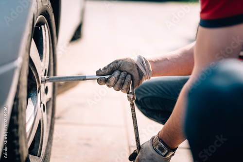 Details of mechanic changing tires, working in workshop and making repairs on automobiles photo