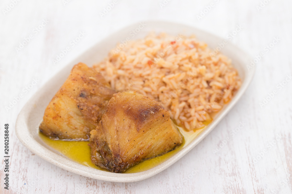 fried cod fish with rice on dish on wooden background fried cod fish with rice on dish on wooden background