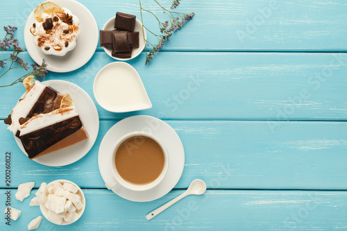 Coffee cup and sweets on blue vintage wooden table, top view