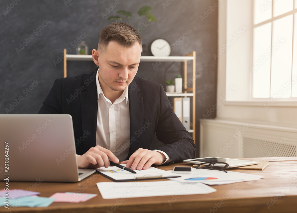Serious man office worker is reading report Serious man office worker is reading report