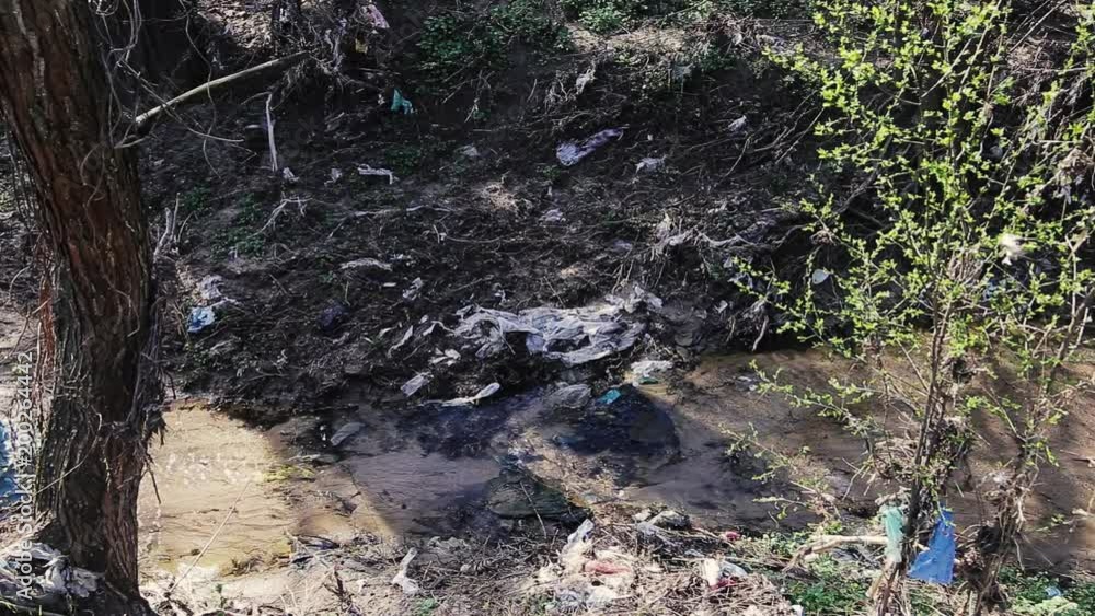 Heavy polluted water stream with domestic garbage Heavy polluted water stream with domestic garbage