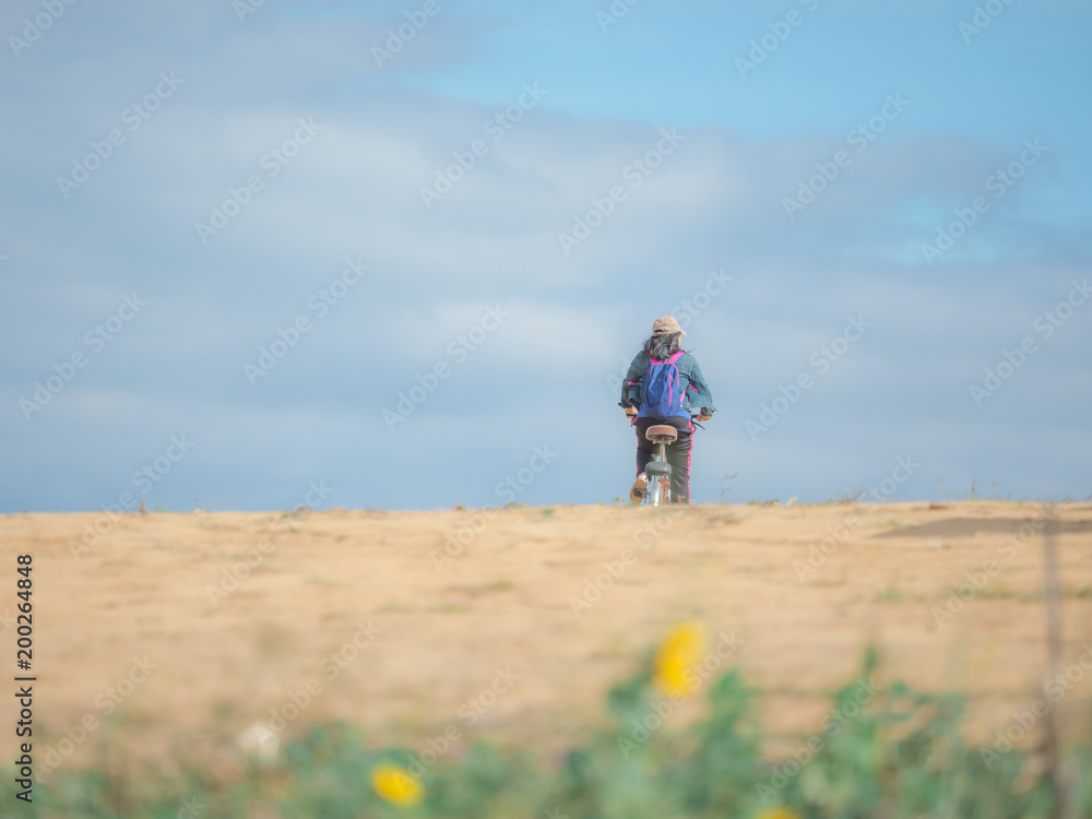 summer and asia travel concept from camping activity with asian woman bike the bicycle on mountain with beautiful sky background