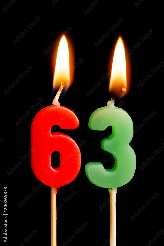 Burning candles in the form of 63 sixty three (numbers, dates) for cake isolated on black background. The concept of celebrating a birthday, anniversary, important date, holiday, table setting Burning candles in the form of 63 sixty three (numbers, dates) for cake isolated on black background. The concept of celebrating a birthday, anniversary, important date, holiday, table setting