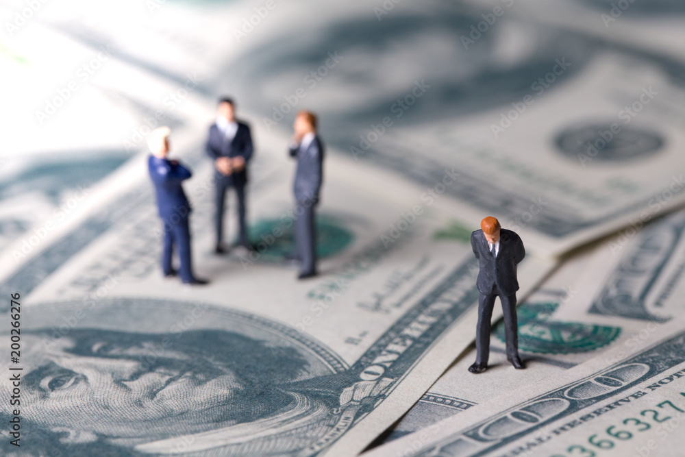 Miniature figurine toys standing on dollar with money and work concept. Focus on the businessman. Miniature figurine toys standing on dollar with money and work concept. Focus on the businessman.