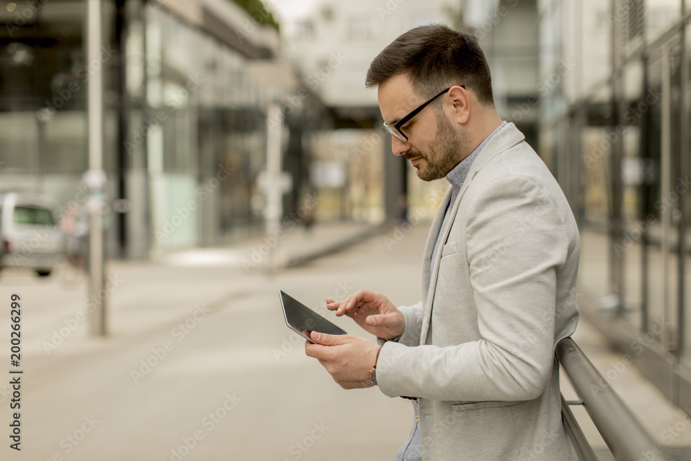 Young businessman with digital tablet by the office building Young businessman with digital tablet by the office building