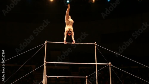 Acrobats perform exercises on the bar in the circus arena