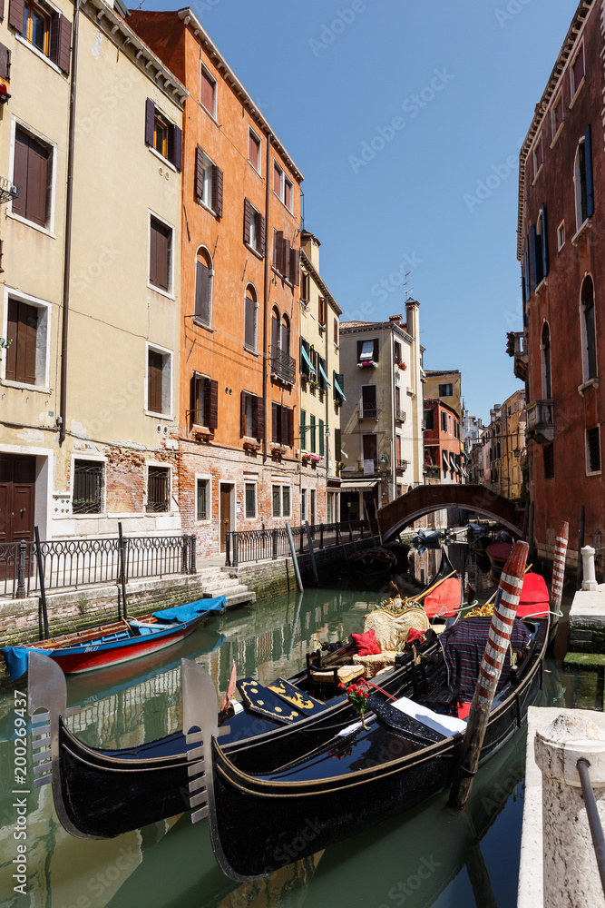Typical view of gondolas and boats on the canal of Venice. Sunny summer day