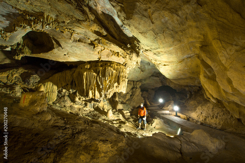 Man exploring beautiful cave at Nguom ngao cave near Ban Gioc waterfalls , Cao bang - North of Vietnam.