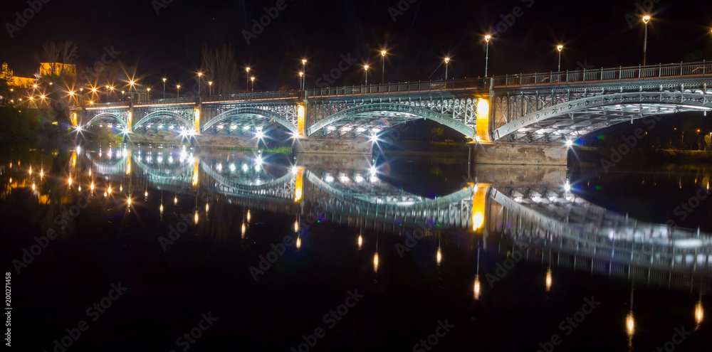 View of illuminated bridge over the Tormes river in Salamanca, Spain