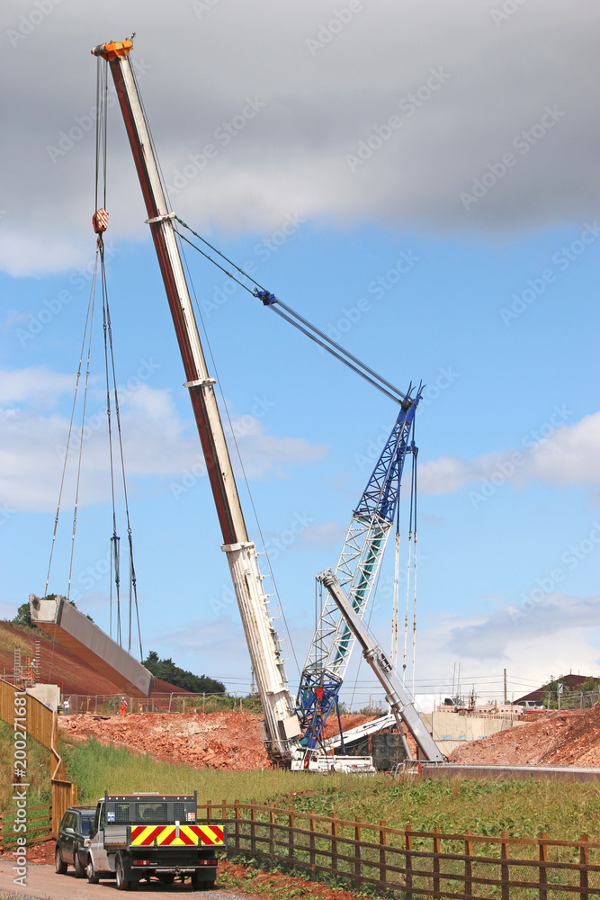 Fototapeta premium Crane lifting a bridge beam