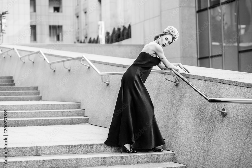 attractive woman in long evening black dress posing on steps of granite staircase attractive woman in long evening black dress posing on steps of granite staircase