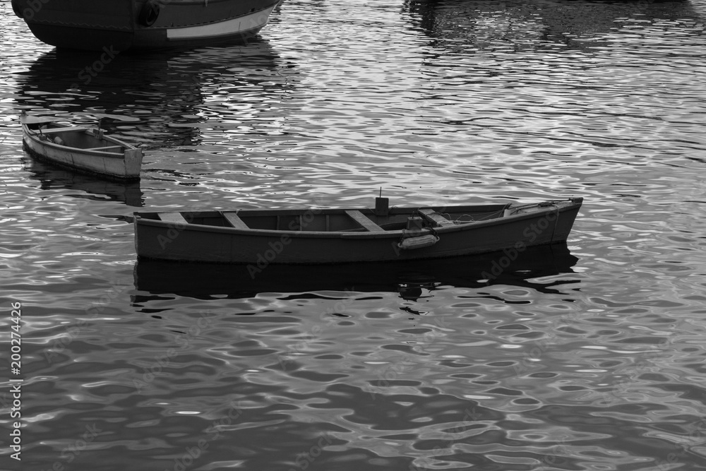photograph black and white small wooden fishing boats without anyone stopping in Urca lake city of rio de janeiro 2018