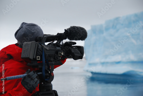 Cameraman filming an iceberg in Antarctica