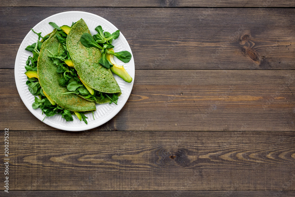 Healthy vegetable pancake. Spinach pancakes on dark wooden background top view copy space Healthy vegetable pancake. Spinach pancakes on dark wooden background top view copy space