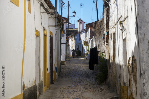 Nisa  Portugal - November 12  2017  Woman walking along a narrow cobblestone street in the village of Nisa  Alentejo  Portugal
