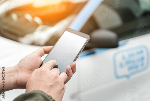 Man calls car with mobile phone APP in parking lot