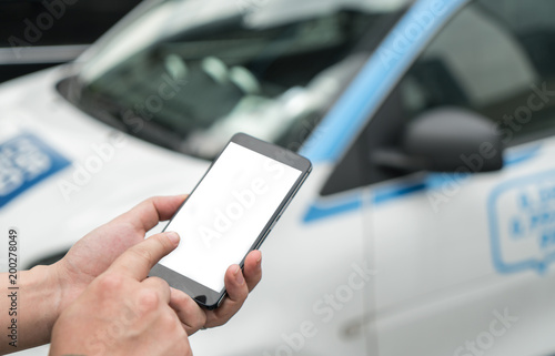 Man calls car with mobile phone APP in parking lot