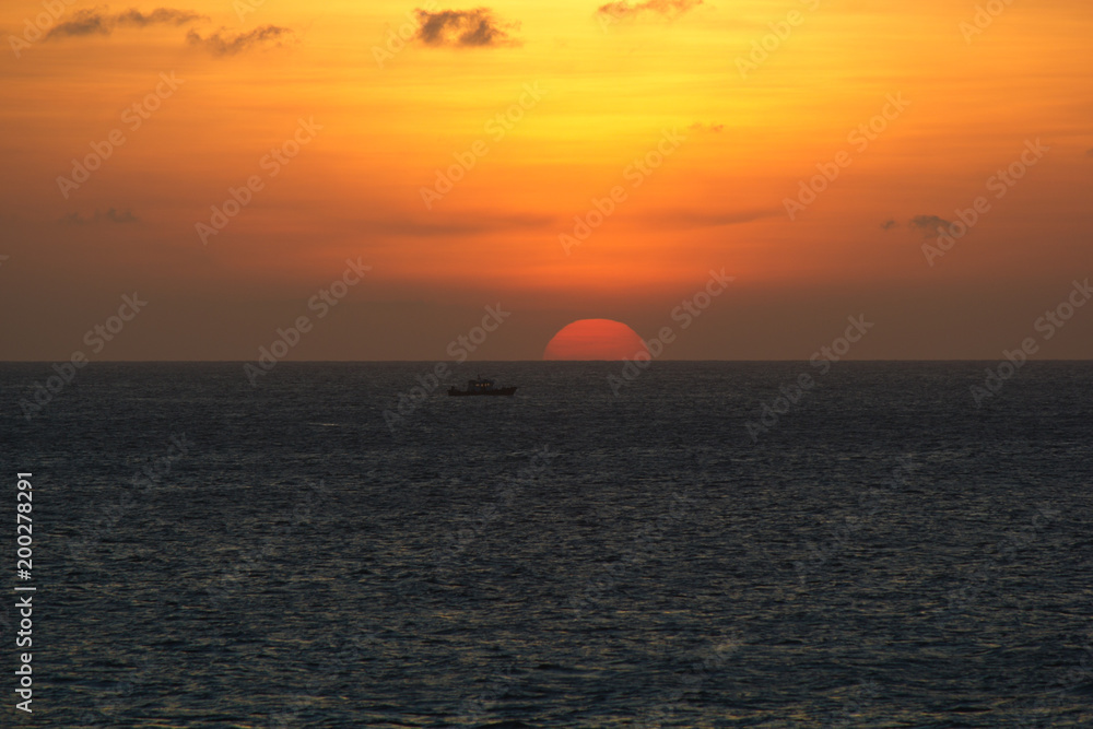 Sunset with a semi circle orange sun over the sea