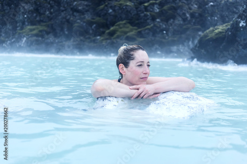 woman leaning on a rock in a hot spring