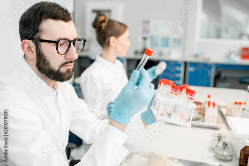 Male laboratory assistant examining test tube in the bacteriological department of laboratory