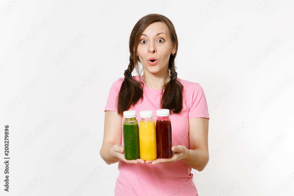 Fun woman holds row of green, red, yellow detox smoothies in bottles isolated on white background. Proper nutrition, vegetarian drink, healthy lifestyle, dieting concept. Copy space for advertisement. Fun woman holds row of green, red, yellow detox smoothies in bottles isolated on white background. Proper nutrition, vegetarian drink, healthy lifestyle, dieting concept. Copy space for advertisement.
