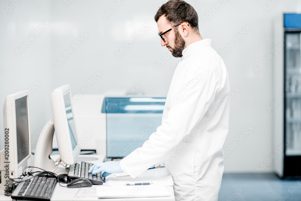 Male technician working with analyzer machine at the laboratiry