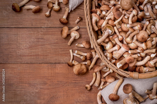 brown wooden background with wicker basket of mushrooms