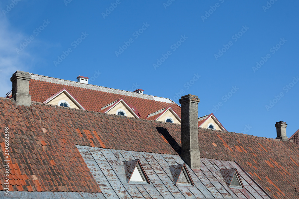 Tiled roofs with chimneys against the sky Tiled roofs with chimneys against the sky