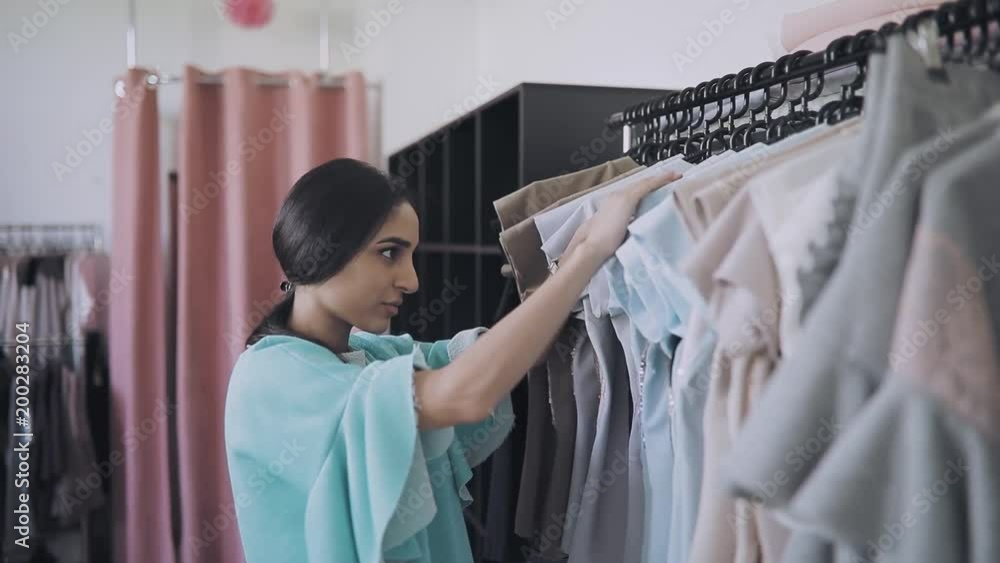 Young woman choise clothes in showroom Young woman choise clothes in showroom