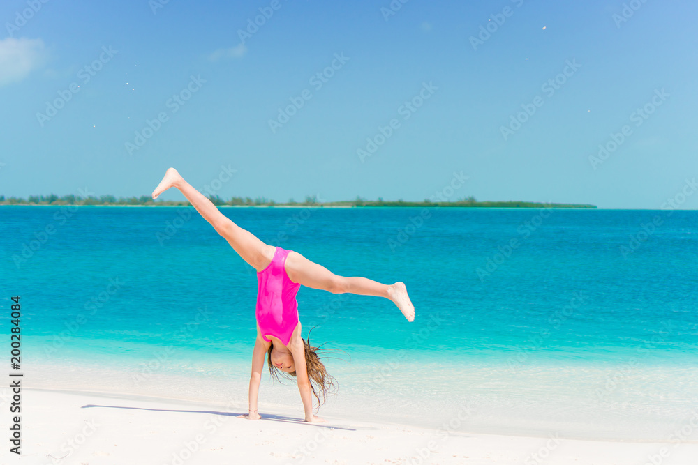Active little girl at beach having a lot of fun on the shore Stock