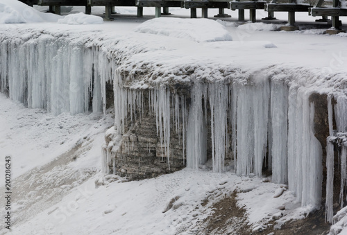 Lengthy icicles flowing over edge near geyser walkway © latitude59