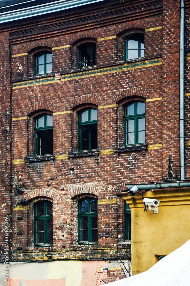 old tenement house with windows and brick wall