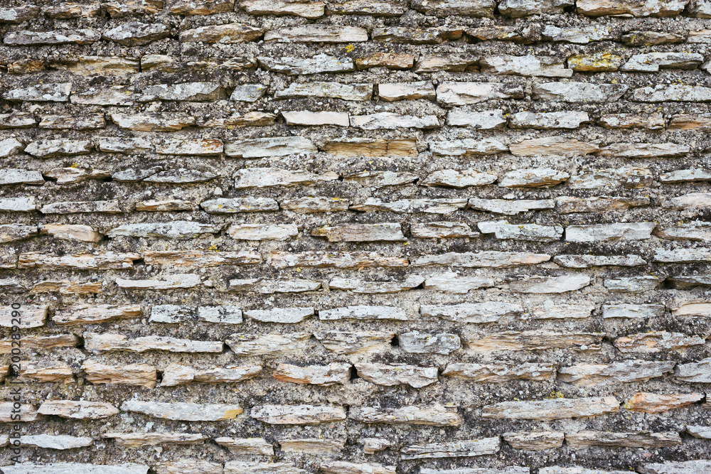 Fototapeta premium Ancient gray brick wall. Antique stone texture.