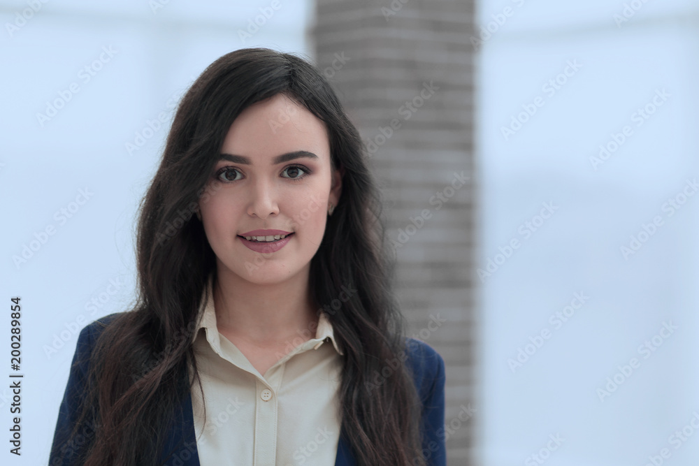 Attractive smiling young business woman in an office. Attractive smiling young business woman in an office.