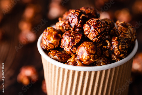 Popcorn in chocolate. Plate. top view. On the background of light wood. copy space.