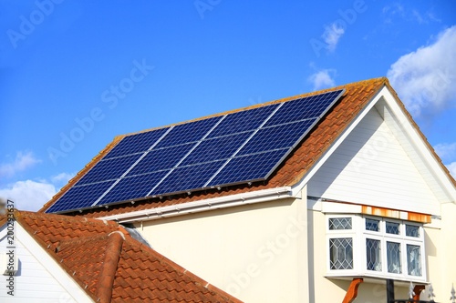 Solar panel on top of a roof with blue sky in the background no people stock photo